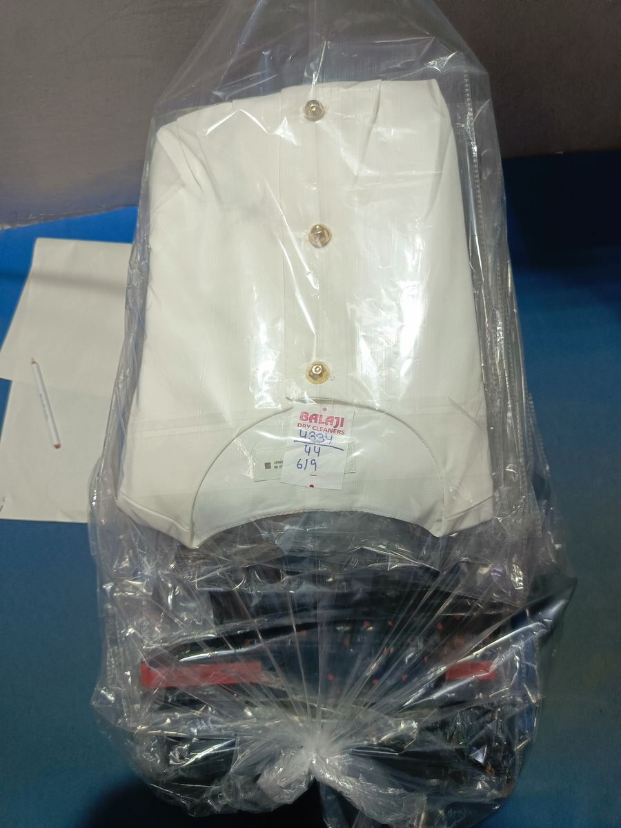 A pressed shirt packed with a Balaji Dry Cleaners tag